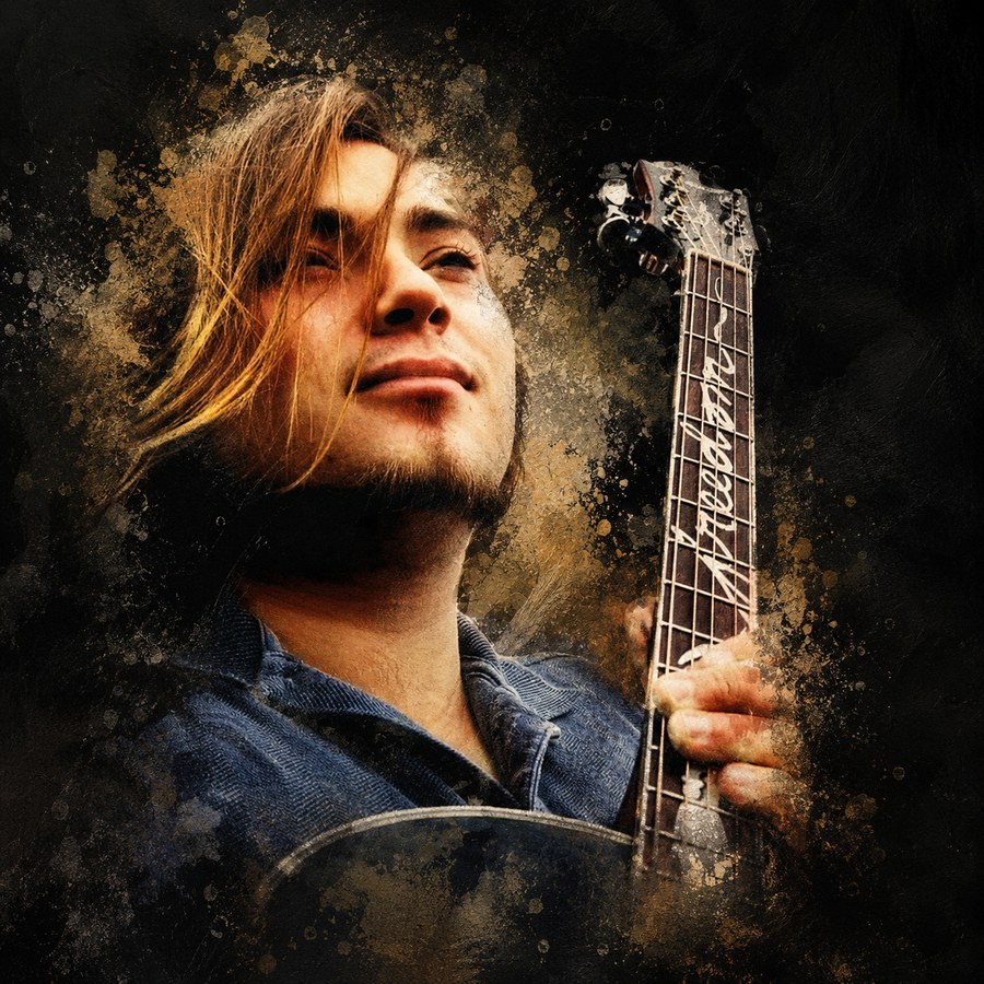 Mikee Jones holding his guitar